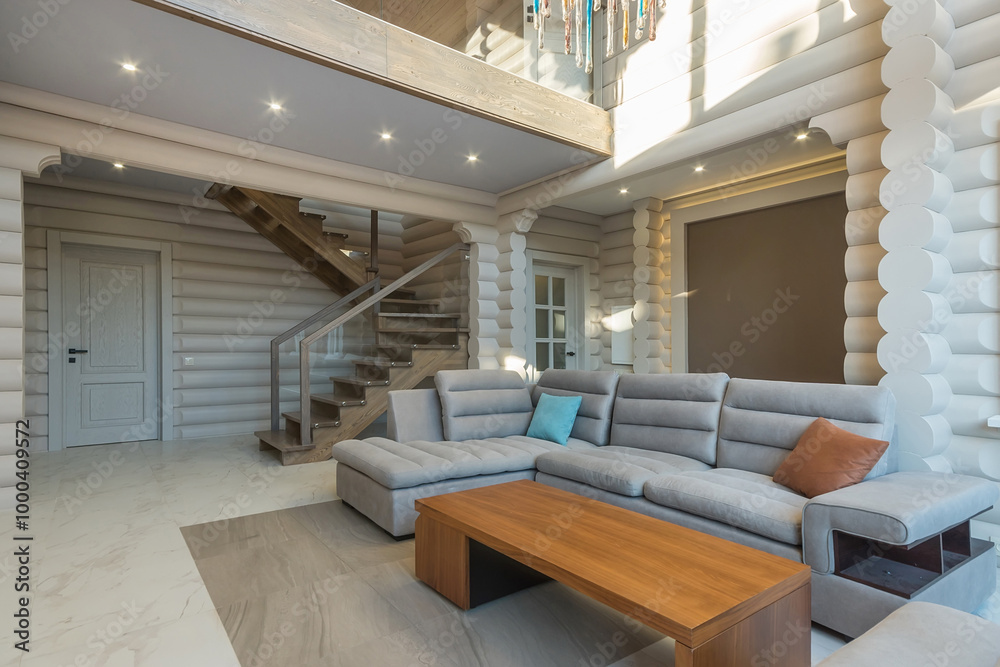 The interior of the living room in a wooden house made of light logs with an exclusive .design. The room is illuminated by the rays of the sun. The interior of the living room in a wooden house made of light logs with an exclusive .design. The room is illuminated by the rays of the sun.