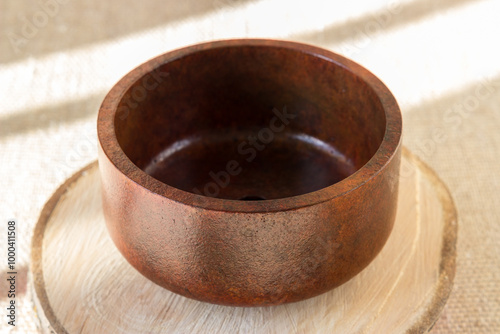 A flower pot for bonsai in red-brown color on a wooden cut.