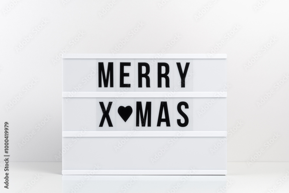 Lightbox with text MERRY XMAS on white table. Minimal Christmas or New Year concept. Lightbox with text MERRY XMAS on white table. Minimal Christmas or New Year concept.
