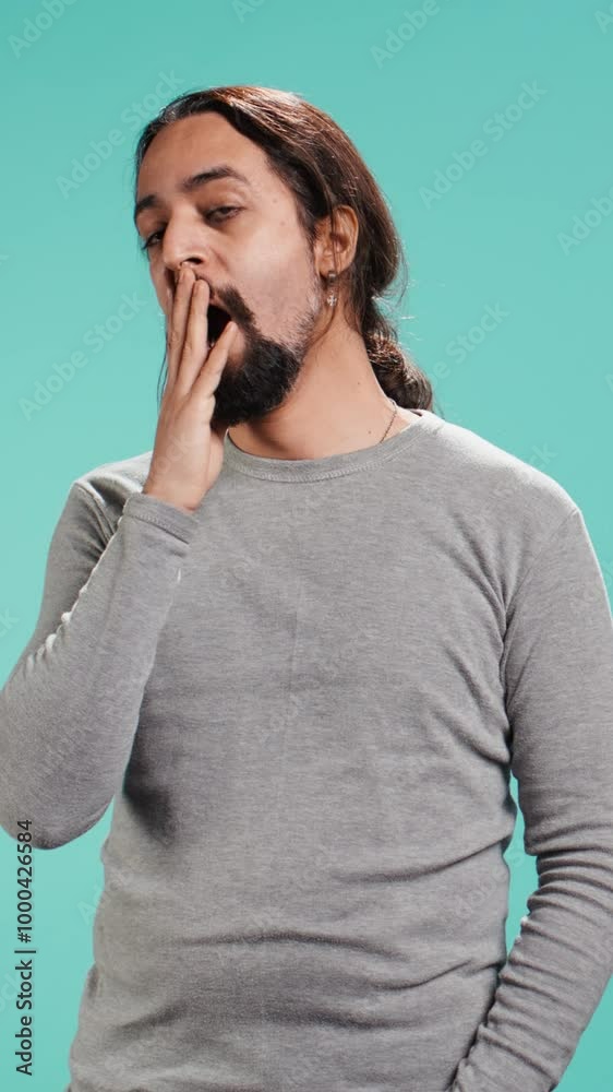 Vertical video Portrait of bored man lacking enthusiasm to do anything, yawning, wasting time, isolated over studio background. Lazy person living monotonous life, having sleepy dull facial expression Vertical video Portrait of bored man lacking enthusiasm to do anything, yawning, wasting time, isolated over studio background. Lazy person living monotonous life, having sleepy dull facial expression