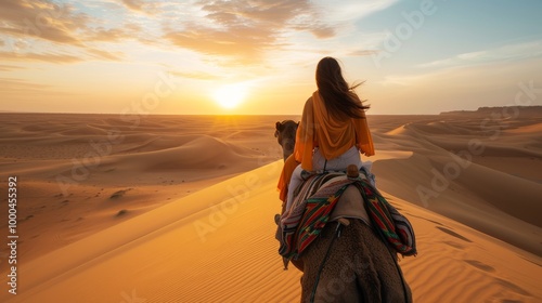 A woman rides a camel through an expansive desert at sunset, her orange shawl blowing in the wind. The scene evokes a sense of adventure and tranquility in the vast dunes. photo