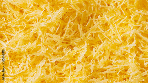 a close-up, top-down view of shredded lemon zest spread across the entire frame, filling the image with their bright yellow color and finely grated texture photo