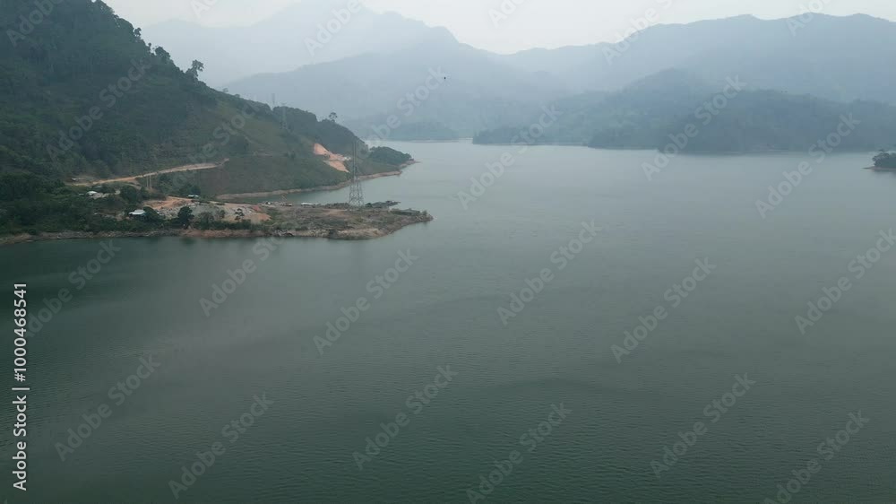 motorcycle and truck driving over the dam that crosses the lake and the valley between the mountains of vietnam motorcycle and truck driving over the dam that crosses the lake and the valley between the mountains of vietnam