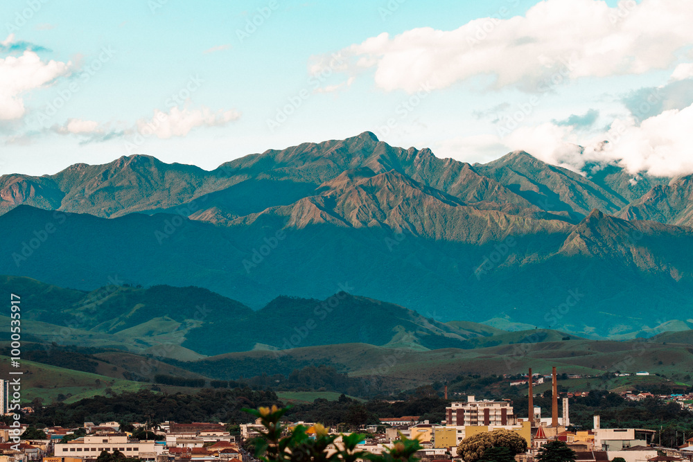 Stunning landscape showcasing mountain ranges under a clear blue sky, with a town nestled in the valley below. The scene captures the serene beauty of the mountainous region. Stunning landscape showcasing mountain ranges under a clear blue sky, with a town nestled in the valley below. The scene captures the serene beauty of the mountainous region.