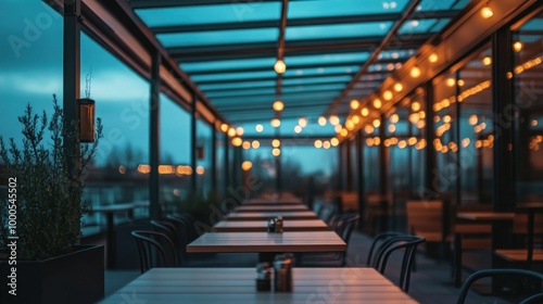 A cozy restaurant terrace illuminated by string lights, featuring empty tables and a serene ambiance.