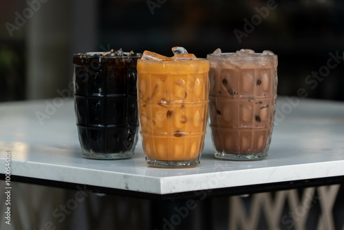 Cha Thai, Ovaltine, and Oliang: Trio of Refreshing Beverages on a White Table photo