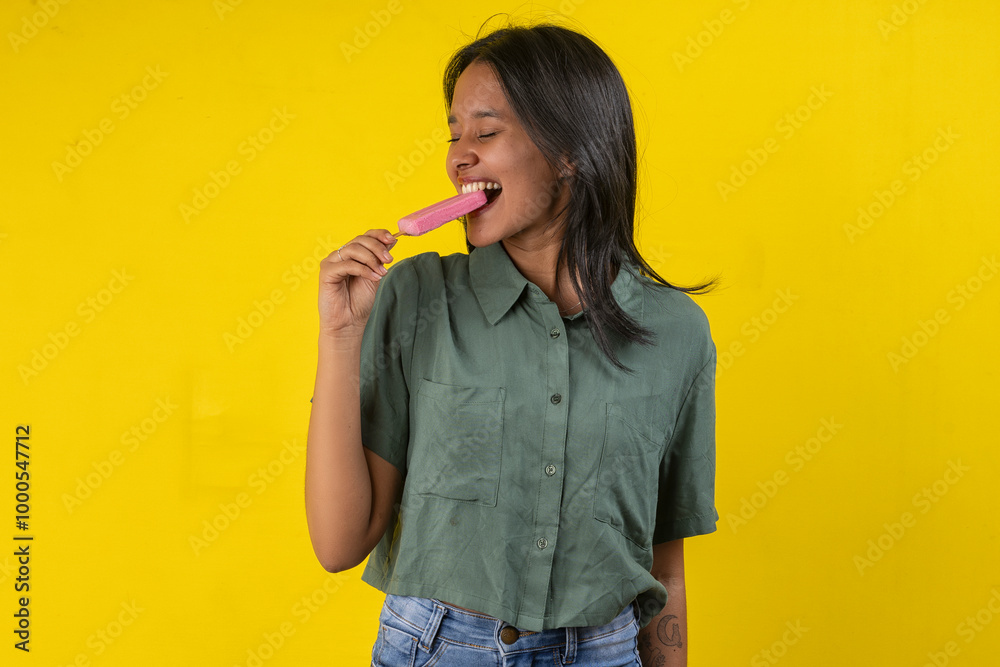 Young woman in studio photo with a strawberry popsicle in her hand Young woman in studio photo with a strawberry popsicle in her hand