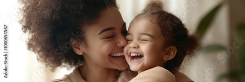 overjoyed smiling young mother and daughter hugging and laughing at home photo