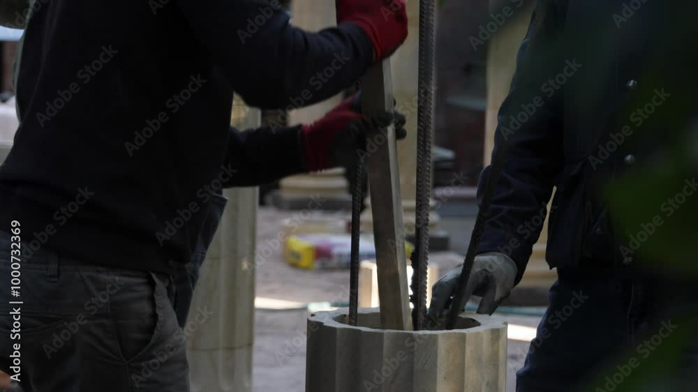 a worker pours cement into the column a worker pours cement into the column