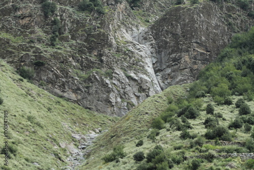 A rugged black stone formation on a barren mountainside, devoid of trees or vegetation.