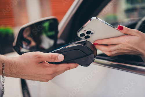 Cropped photo of woman driving auto paying modern device terminal outdoors urban city street