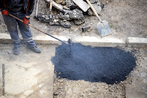 Utility workers are laying new asphalt.