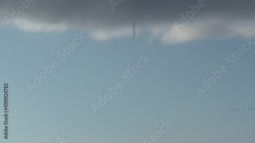 A vertical pan shows the formation of a waterspout, as the column begins to take shape between the clouds and the ocean surface. Captured during the early stage of the vortex forming. Check my portfol photo