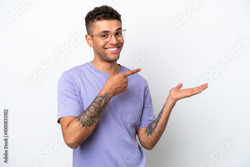 Young caucasian Brazilian man isolated on white background holding copyspace imaginary on the palm to insert an ad photo