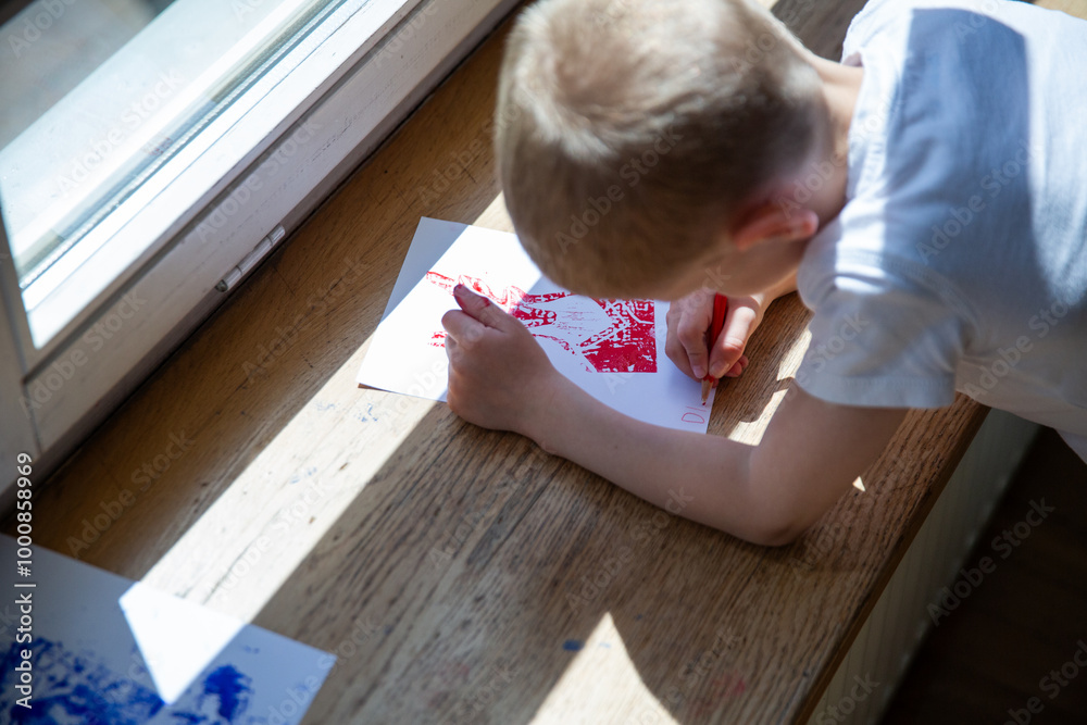 Children creating lino cut prints on paper using rollers, paint, and spoons in an art workshop. Creativity, craft techniques, and artistic expression, educational and creative stock imagery. Children creating lino cut prints on paper using rollers, paint, and spoons in an art workshop. Creativity, craft techniques, and artistic expression, educational and creative stock imagery.