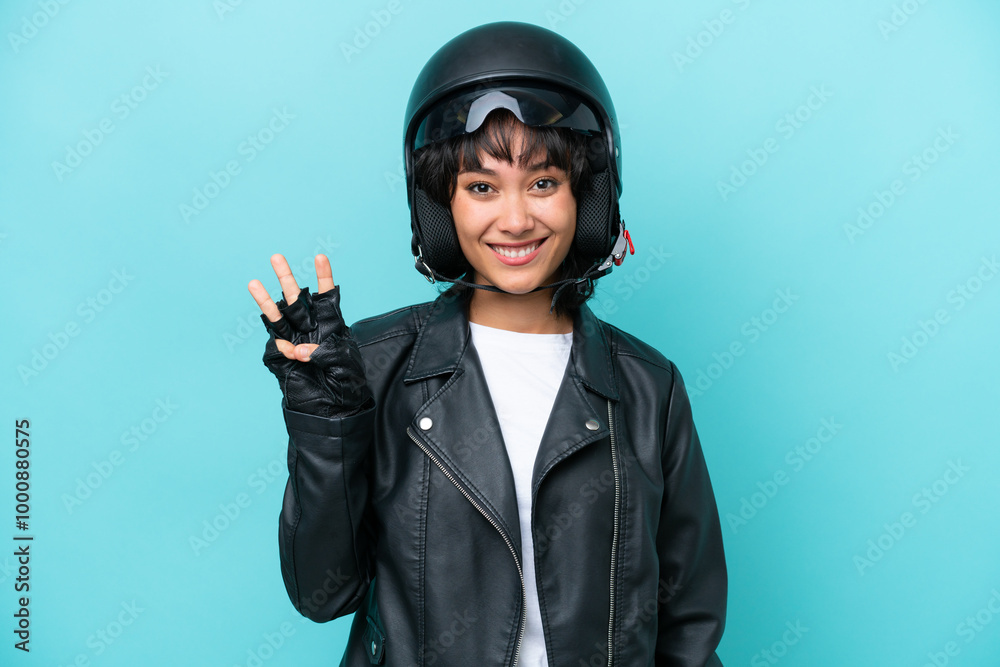 Young Argentinian woman with a motorcycle helmet isolated on blue background happy and counting three with fingers Young Argentinian woman with a motorcycle helmet isolated on blue background happy and counting three with fingers