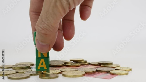 Write WOMAN single word on wooden cubes with euro coins and white background.