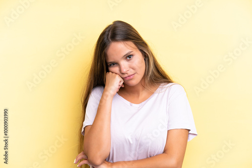 Young caucasian woman isolated on yellow background with tired and bored expression