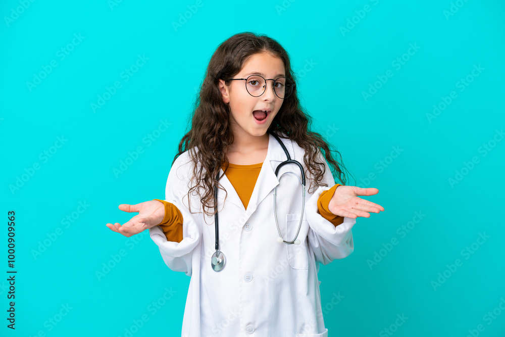 Little doctor girl isolated on blue background with shocked facial expression Little doctor girl isolated on blue background with shocked facial expression