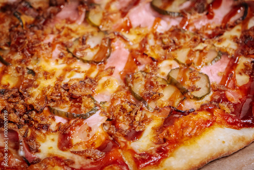 A delicious pizza topped with thin slices of prosciutto, melted cheese, and caramelized onions on a crispy golden crust. The rich colors and textures highlight the mouth-watering ingredients.