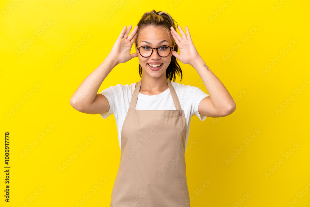 Restaurant waiter Russian girl isolated on yellow background with surprise expression Restaurant waiter Russian girl isolated on yellow background with surprise expression
