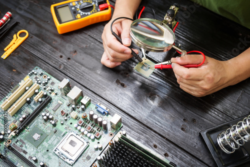 Technician carefully repairs a computer circuit board, using precision tools to address hardware issues. technical expertise needed for troubleshooting and upgrading electronic systems in workspace.