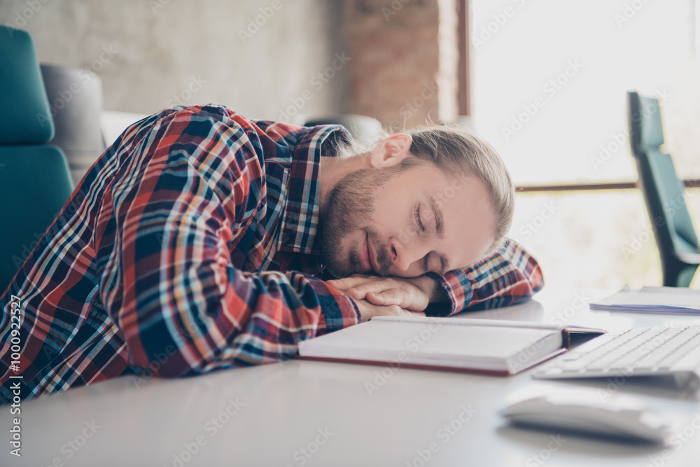 Photo of nice young man company worker sleep desk wear checkered shirt modern loft office indoors Photo of nice young man company worker sleep desk wear checkered shirt modern loft office indoors