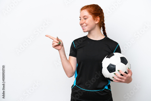 Young caucasian reddish football player woman isolated on white background pointing finger to the side and presenting a product photo