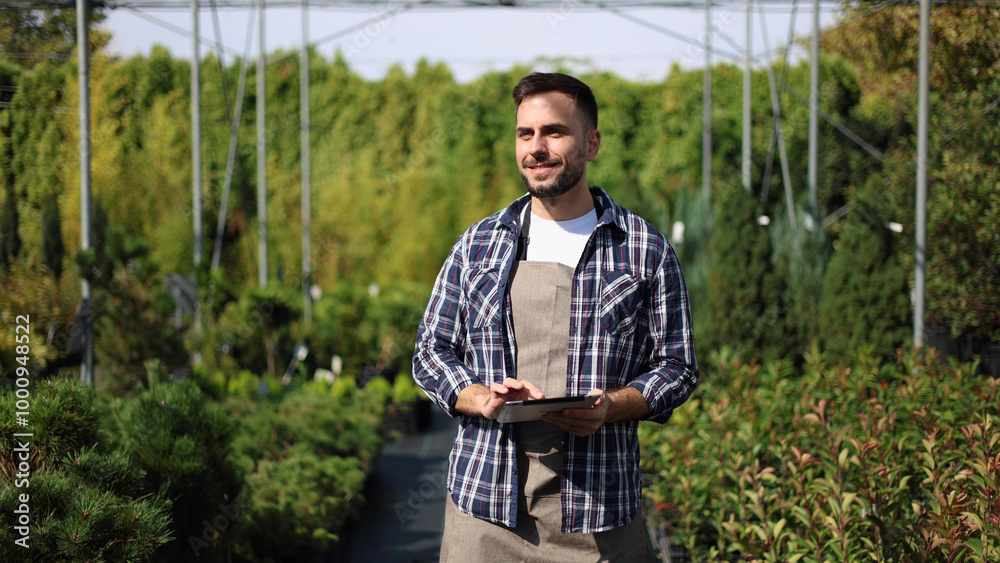 Worker is caring for the plants at the garden center Worker is caring for the plants at the garden center