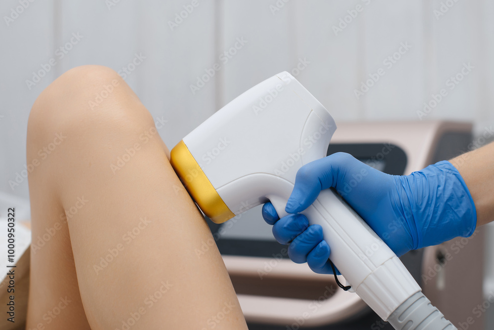 Fototapeta premium laser epilation, hair removal procedure, young beautiful caucasian smiling brunette woman lying on couch in beauty salon, legs epilation, spa and cosmetology concept