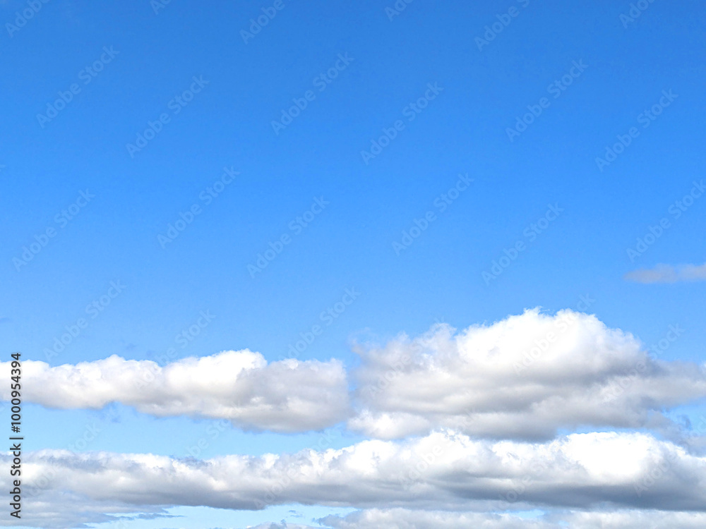 Fluffy White Clouds in a Blue Sky as A Skyscape Background Fluffy White Clouds in a Blue Sky as A Skyscape Background