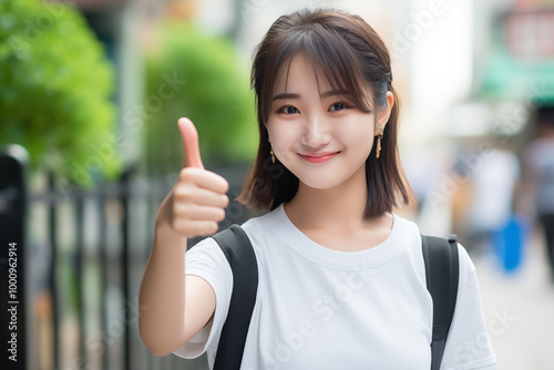 Teen pretty Japanese girl at outdoors with thumb up