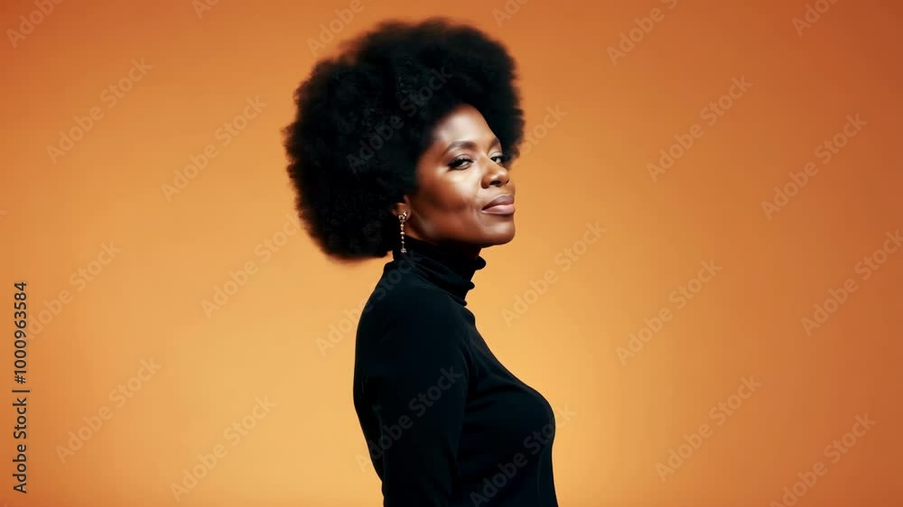 Confident woman with natural afro hairstyle on vibrant orange background Confident woman with natural afro hairstyle on vibrant orange background