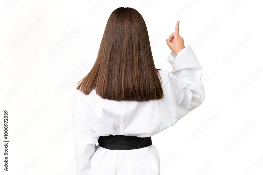 Little Caucasian girl doing karate over isolated background pointing back with the index finger Little Caucasian girl doing karate over isolated background pointing back with the index finger