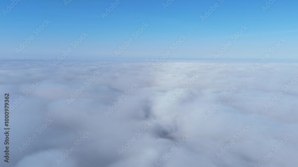 Aerial view of a vast cloudscape from above on a clear day. Drone video of an expansive view of low clouds from above, with a bright blue sky in the background. Aerial view of a vast cloudscape from above on a clear day. Drone video of an expansive view of low clouds from above, with a bright blue sky in the background.