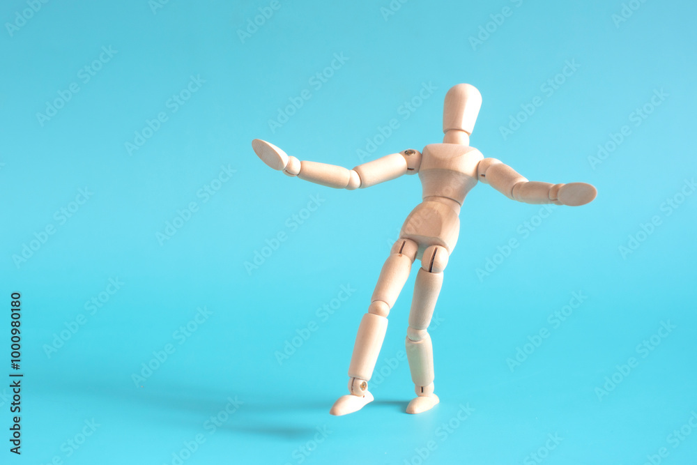 The concept of a cautious person who takes a step forward. A wooden doll takes a cautious step forward against a light background. The concept of a cautious person who takes a step forward. A wooden doll takes a cautious step forward against a light background.