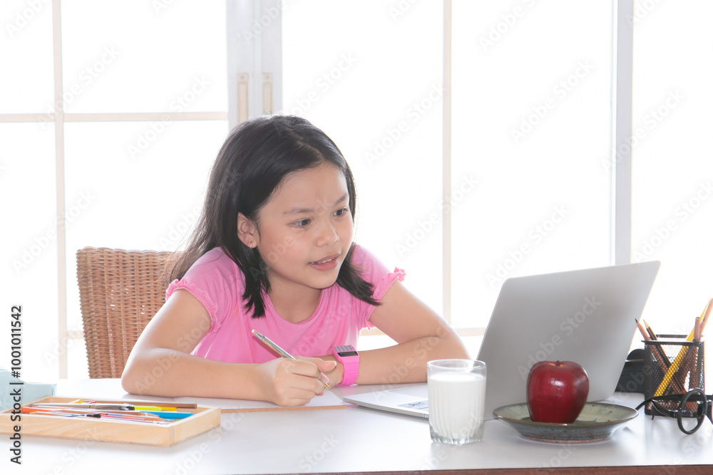 Adorable Asian girl happy learning online with technology laptop on desk at home, school girl typing answer or response with teacher study homeschool or learn from home, smart kids with technology Adorable Asian girl happy learning online with technology laptop on desk at home, school girl typing answer or response with teacher study homeschool or learn from home, smart kids with technology