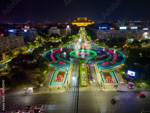 Aerial Drone point of view of Unirii Water Fountains illuminated at night. City center of Bucharest at night. Light shows every weekend, in summer. Capital cities. #1001011947