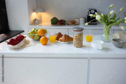 Breakfast food on light table in modern kitchen croissant and oatmel photo