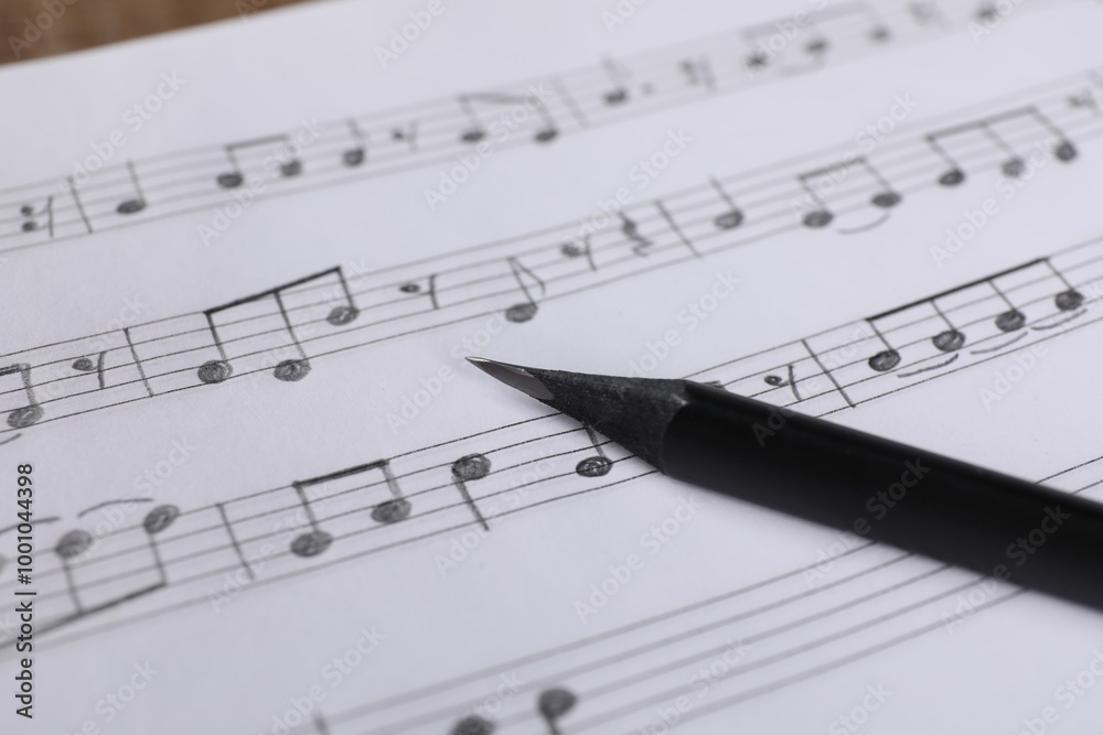 Sheet with musical notes and pencil, closeup view Sheet with musical notes and pencil, closeup view