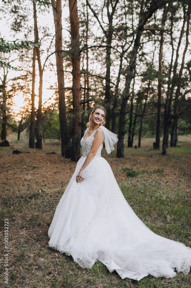 Wedding photography, portrait of a beautiful smiling curly blonde bride in a long dress in a pine forest at sunset. Wedding photography, portrait of a beautiful smiling curly blonde bride in a long dress in a pine forest at sunset.