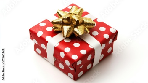 New Year present wrapped in red paper with white polka dots and a gold bow, isolated on a white background.