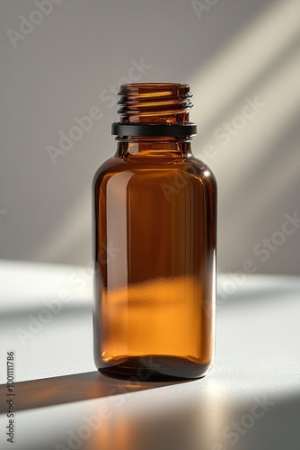 A clear amber glass bottle with a screw top, reflecting light on a surface.