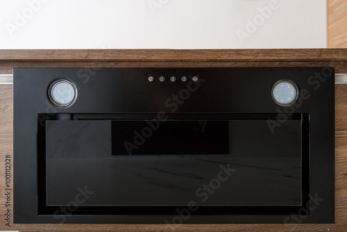 Modern kitchen appliance mounted in a sleek cabinet with touch controls and built-in lighting