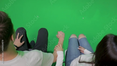 people pretend to fly a plane or a spaceship on a green background