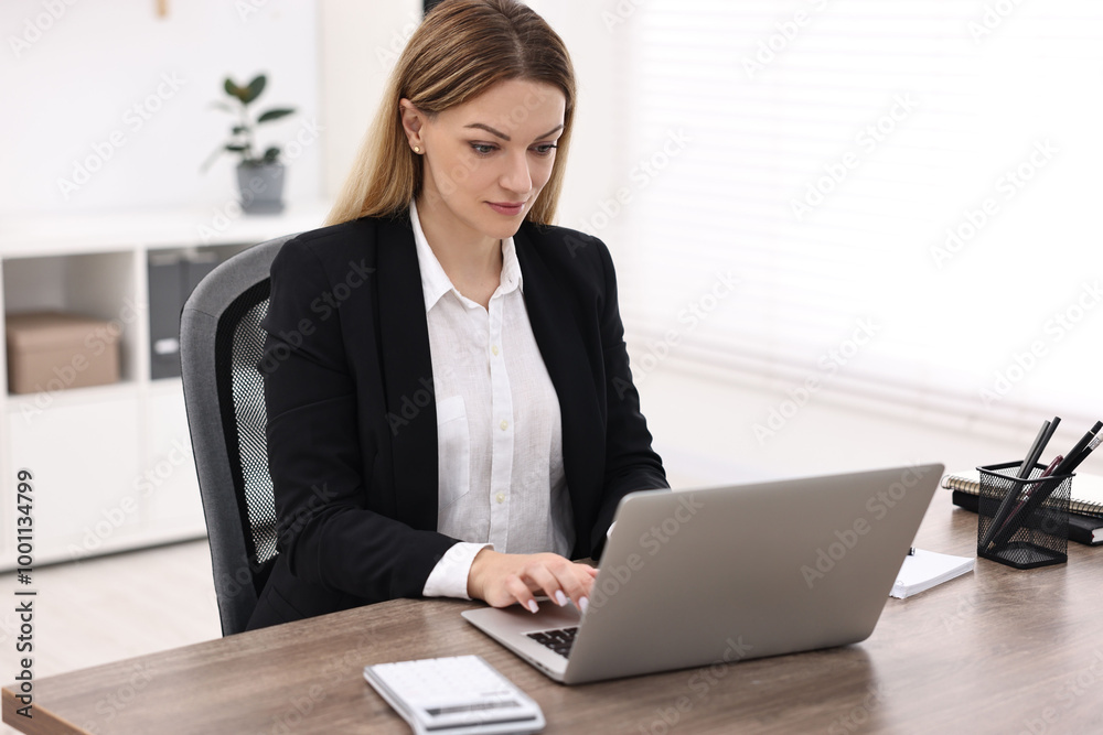 Banker using laptop at wooden table in office Banker using laptop at wooden table in office