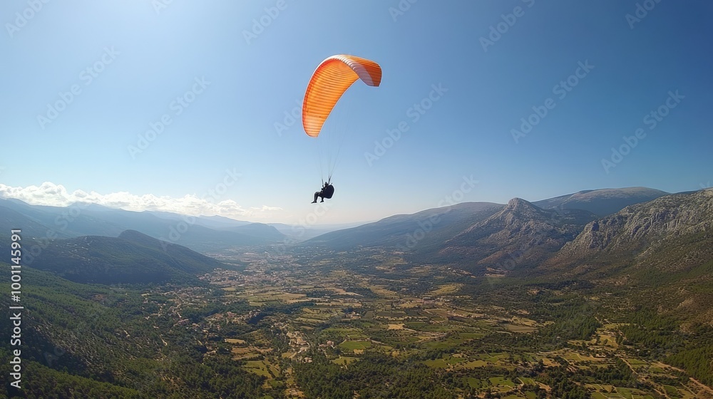 Paraglider Soaring Above a Green Valley with Mountains Paraglider Soaring Above a Green Valley with Mountains