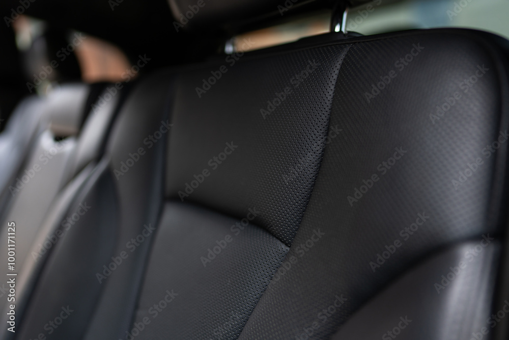 Close up view of rear seats in expensive vehicle covered by refined leather upholstery. Four-way lumbar support for passengers' comfort Close up view of rear seats in expensive vehicle covered by refined leather upholstery. Four-way lumbar support for passengers' comfort