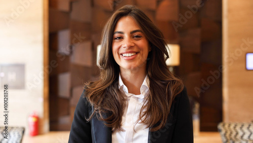 Quadro su tela Confident young woman smiles as she stands in the sleek lobby of her company
