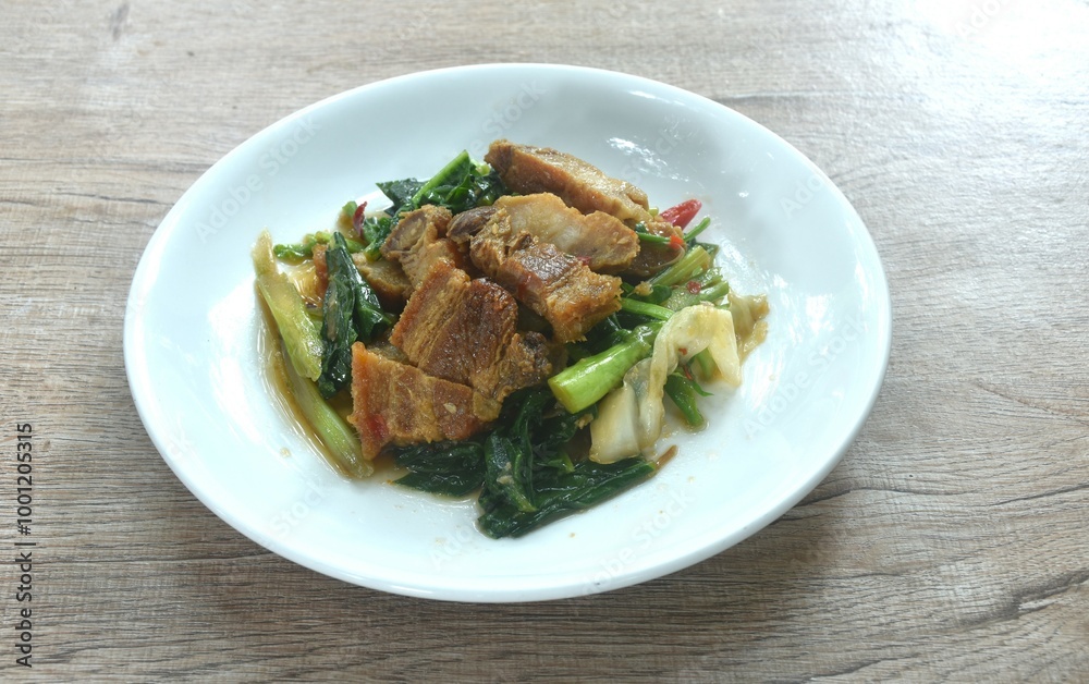 fried Chinese kale and cabbage with crispy pork in soy sauce on plate fried Chinese kale and cabbage with crispy pork in soy sauce on plate